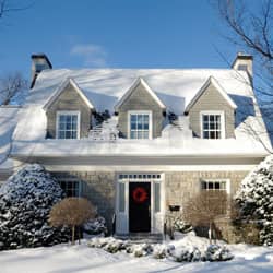 The facade of a house with white paint covered in snow
