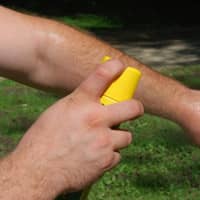 Man using bug spray with DEET.