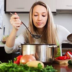 A woman cooking on a stove in her kitchen
