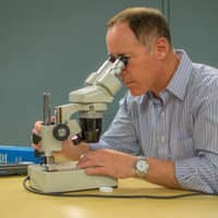 A man looking at a microscope