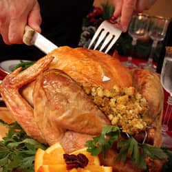 A person cutting a cooked turkey